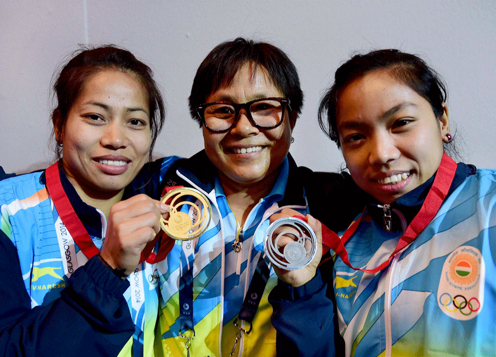 Glasgow: India's gold medalist Sanjita Khumukcham and compatriot silver  medallist Chanu Saikhom celebrate with weightlifting team coach  Kunjarani Devi after their win in women's 48kg weightlifting event at  the Commonwealth Games in Glasgow, Scotla...
