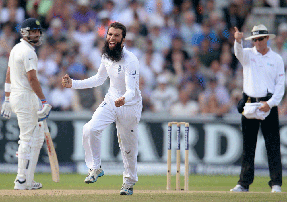 England's Moeen Ali (C) celebrates after dismissing India's Cheteshwar  Pujara (not pictured) during the fourth cricket test match at Old  Trafford cricket ground in Manchester, England August 9, 2014.  REUTERS