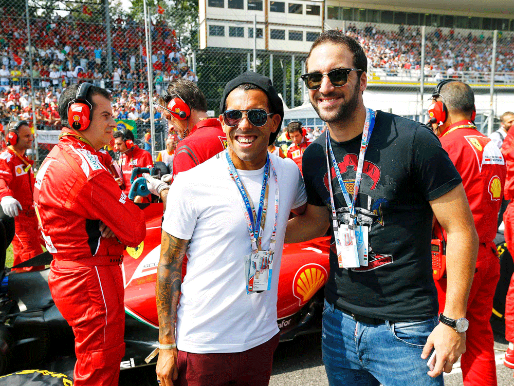 Argentinian soccer players Carlos Tevez (L) of Juventus and Gonzalo Higuain (R) of Napoli poses before the start of the Italian F1 Grand Prix in Monza September 7, 2014. REUTERS
