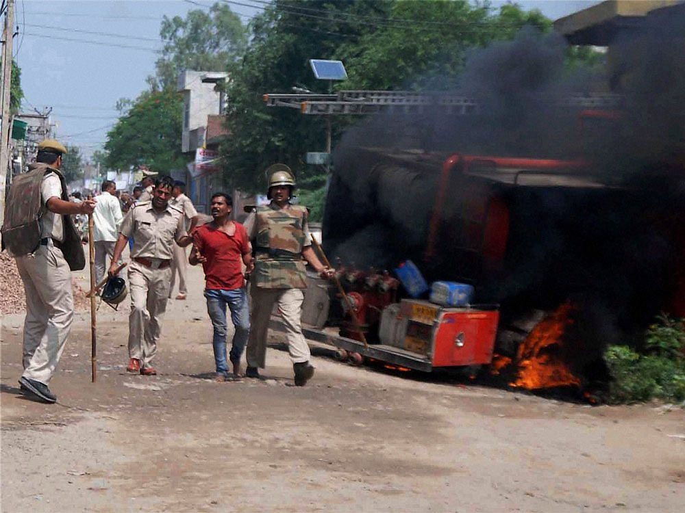 Police reach the spot where an angry mob burned down a fire brigade  vehicle after a young boy died in a road accident in Ballabhgarh,  Faridabad on Saturday. PTI Photo