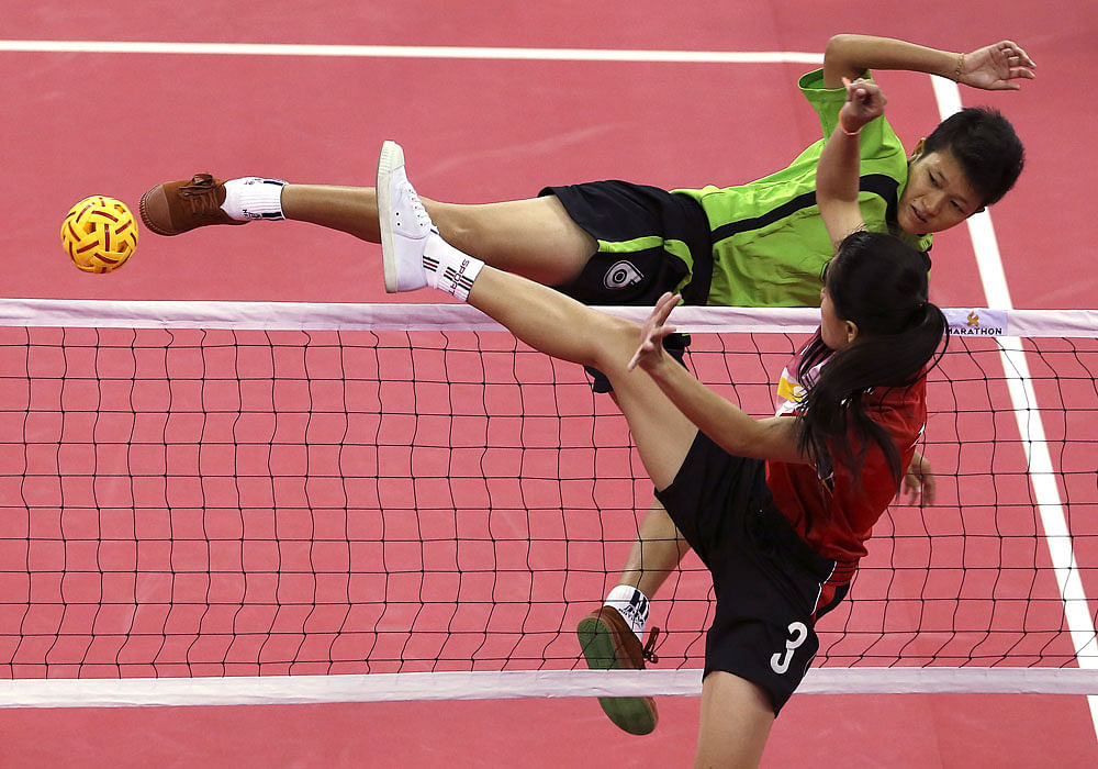 Myanmar's Phyu Phyu Than, top, kicks a ball as Laos's Koy Xayavong,  front, blocks during the women's doubles sepak takraw final match at the  17th Asian Games Monday, Sept. 22, 2014 in Incheon, South Korea. AP  Photo