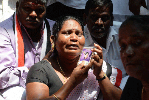 A supporter of AIADMK leader Jayalalithaa cries outside the Karnataka  high court after her conditional bail was rejected in Bengaluru on  Tuesday. PTI Photo