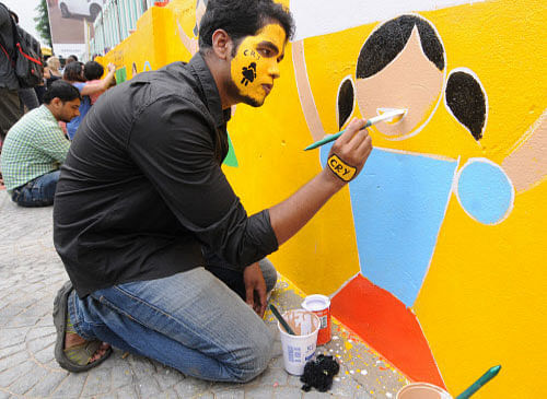 Students  of Raffles Millennium International Bangalore and CRY Child Rights and  You volunteers painting the wall to create awareness on Girl Child  Rights to mark the International Day of the Girl Child, at Hosur Road  near Christian Cemetery in Ba...