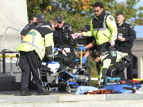 Police and paramedics tend to a soldier shot at the National Memorial near Parliament Hill in Ottawa on Wednesday Oct. 22, 2014. The soldier standing guard at the National War Memorial was shot by an unknown gunman and people reported hearing gunfire...