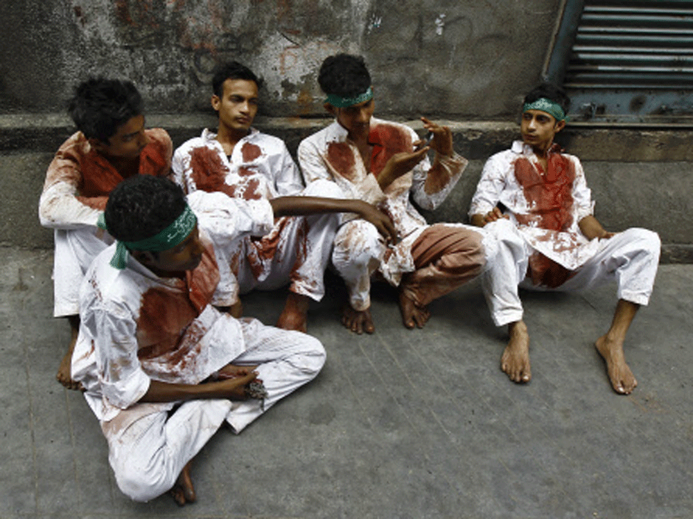 Shi'ite Muslims rest after flagellating themselves in a Muharram procession to mark Ashoura in Kolkata November 4, 2014. Ashoura, which falls on the 10th day of the Islamic month of Muharram, commemorates the death of Imam Hussein, grandson of Prophe...