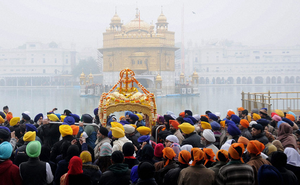 Sikh devotees during a religious procession at Golden Temple on the eve of birth anniversary of Guru Gobind Singh, in Amritsar on Saturday. PTI Photo