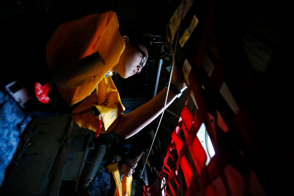 Republic of Singapore Air Force personnel survey the waters during a search and locate operation for the missing AirAsia QZ8501 plane at an undisclosed search area December 30, 2014. Indonesian rescuers searching for the AirAsia plane carrying 162 pe...