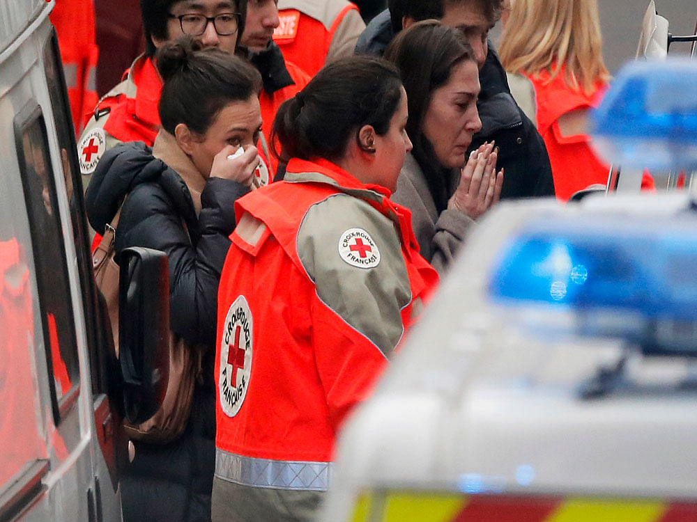 People react as they are evacuated outside the French satirical newspaper Charlie Hebdo's office, in Paris
