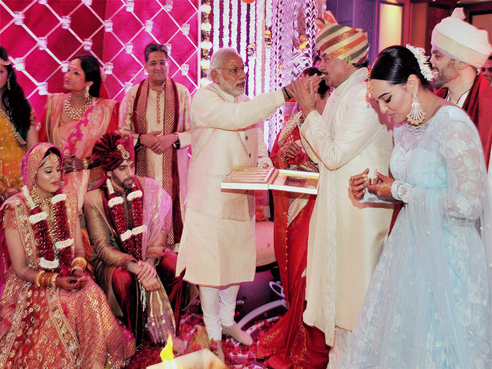 Prime Minister Narendra Modi gives a piece of sweet to Bharatiya Janata Party (BJP) MP Shatrughan Sinha on the occasion of his son, Kussh Sinha's wedding in Mumbai on Sunday. PTI Photo