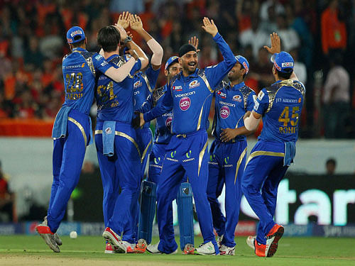 Mumbai Indians players Mitchell McClenaghan, Harbhajan Singh celebrate with team mates, after dismissal of Sunrisers Hyderabad's batsman Eoin Morgan during the IPL match in Hyderabad on Sunday. PTI Photo.
