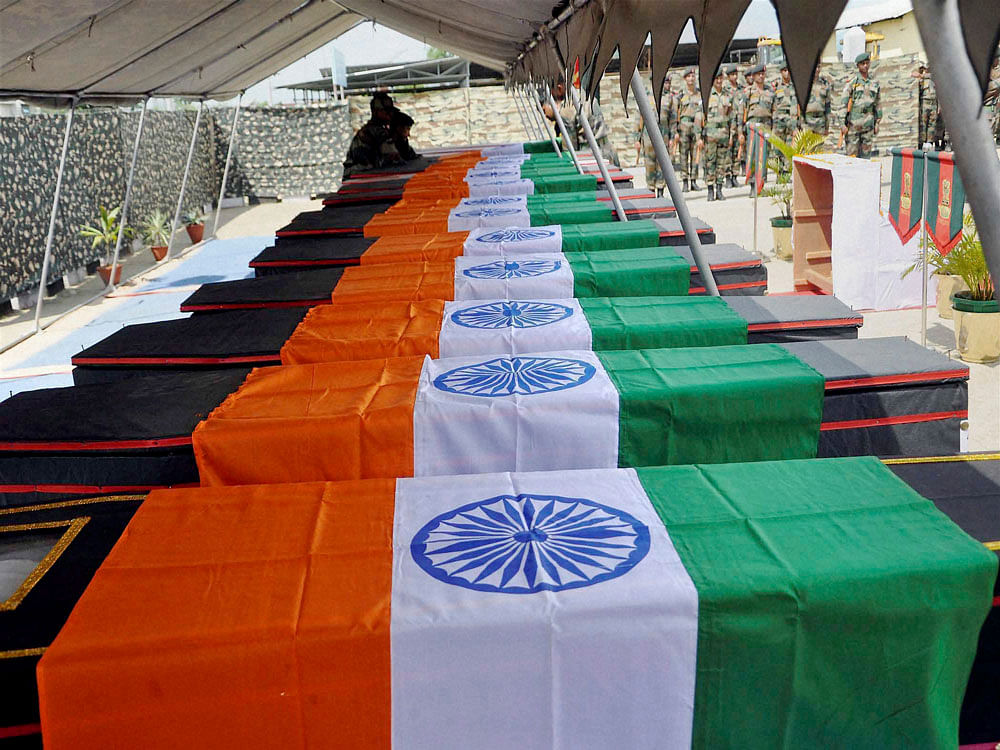  Coffins of the soldiers of Dogra Regiment who were killed in an ambush by the militants, draped in Tri-Colours at a wreath laying ceremony in Imphal on Saturday. PTI  Photo.