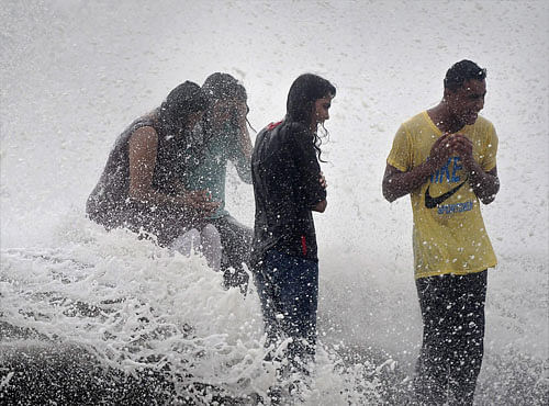 Mumbaikars enjoy high tide at the Marine drive in Mumbai on Monday.