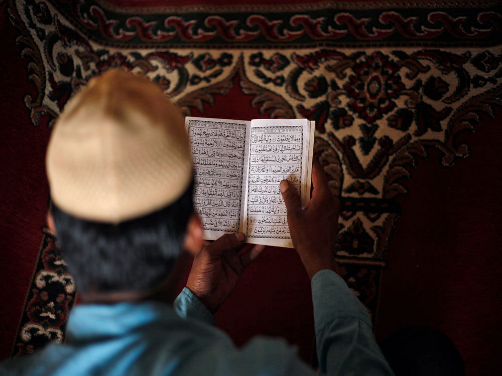 An Indian Muslim man reads the holy Quran at Jami Masjid after Friday prayers in Ahmadabad, India, Friday, June 26, 2015. Muslims throughout the world are celebrating the holy fasting month of Ramadan, refraining from eating, drinking, and smoking fr...