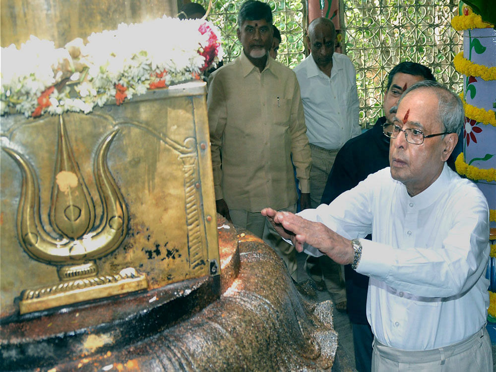 President Pranab Mukherjee offers prayers to the sacred Dwajasthambham (flag-mast) of Lord Shiva at the ancient cave temple of Sri Kapileswara Swamy in Tirupati on Wednesday. Also seen in the photo are Andhra CM N. Chandrababu Naidu and Governor ESL ...