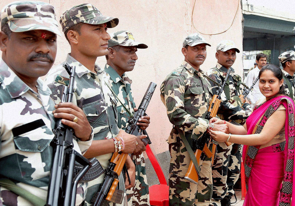 A woman tying Rakhi to army soldiers on eve of Raksha Bandhan festival in Surat on Friday. PTI Photo