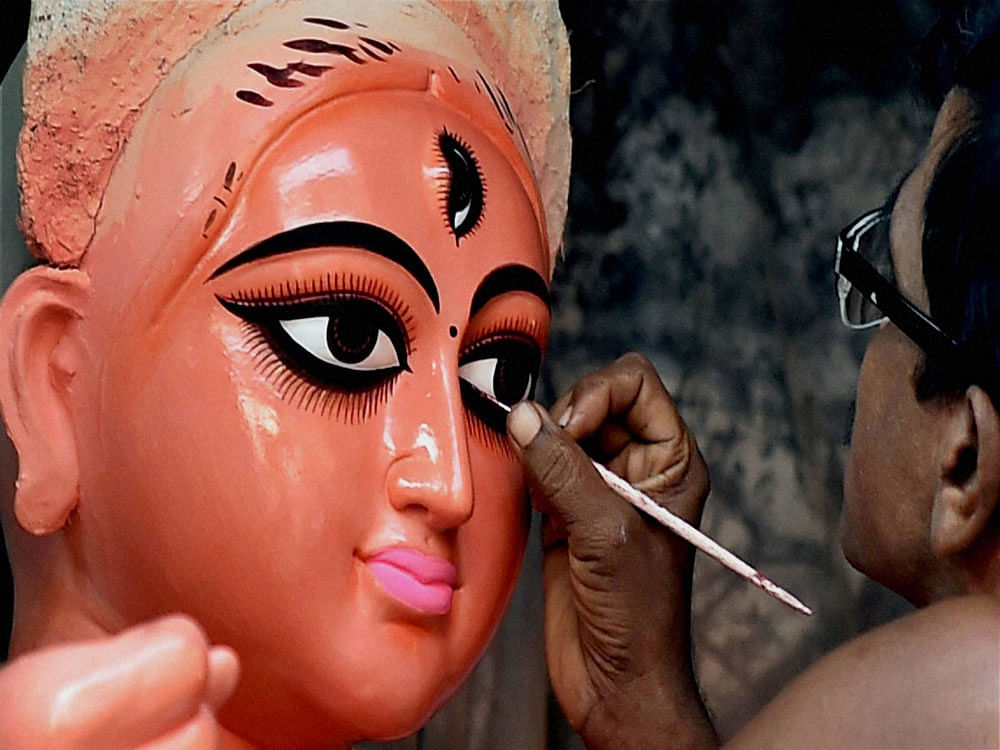 An artist makes Idol of Goddess Durga ahead of the upcoming Durga Puja festival at Kumartuli in Kolkata on Sunday. PTI Photo .