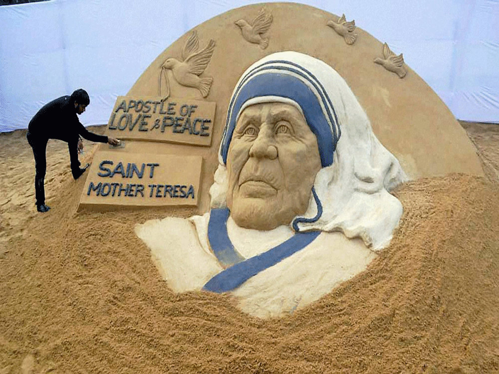 Sand Artist Sudarsan Pattnaik creates a sand sculpture of Mother Teresa with the message 'Apostle of Love & Peace Saint Teresa' at Rourkela Steel City in Sundargarh district on Friday. Mother Teresa will be made a Saint of Roman Catholic Church the n...