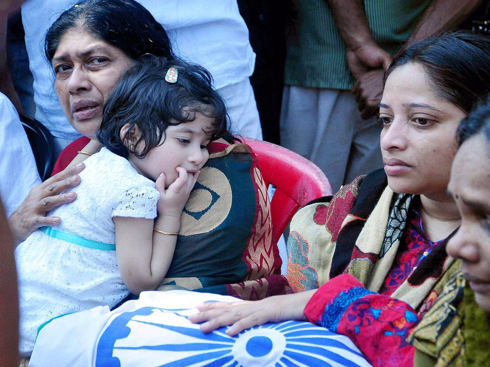 Family members of Lt Col Niranjan Kumar who was martyred in the Pathankot militant attack near his body at Palakkad in Kerala on Tuesday. PTI Photo.