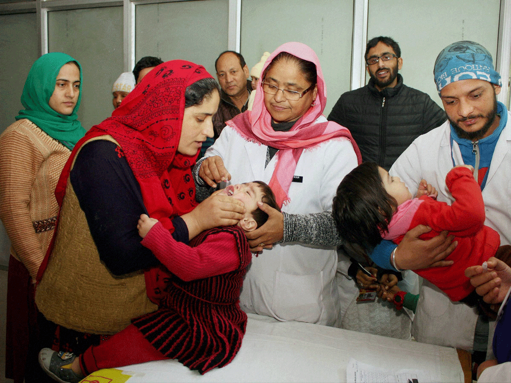 Health officials administer polio vaccine drops to children at a government hospital in Jammu. PTI Photo.