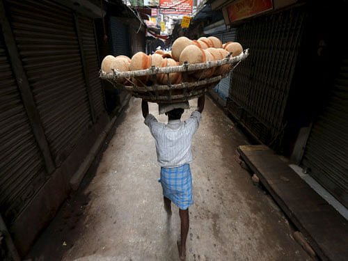 A man carries a basket filled with earthen pots for delivery to a sweet shop through an alley at a market place in Kolkata.  Reuters/Rupak De Chowdhuri