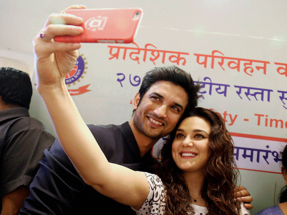 Bollywood actress Priety Zinta takes a selfie with actor Sushant Singh Rajput during National Road Safety Abhiyan event in Thane on Sunday. PTI Photo.