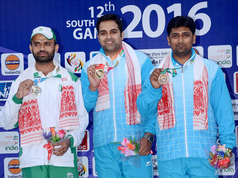 Gold Medal winner Omkar Singh of India, flanked by Silver Medal winner Kameel Ullah (left) of Pakistan and Bronze Medalist Jitendra Vibhute (right) of India during the presentation ceremony of the 10m Air Pistol Men's Individual event at the 12th Sou...