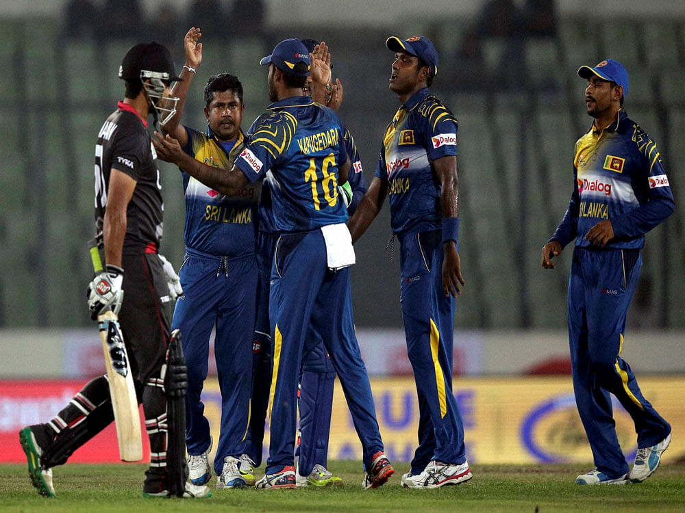Sri Lankan bowler, Rangana Herath, second left, celebrates the dismissal of United Arab Emirates’ Shaiman Anwar, left, with his teammates during the Asia Cup Twenty20 international cricket match between the two countries in Dhaka, Bangladesh, Thurs...