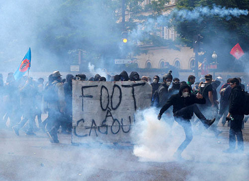 Youth, some carrying a banner reading 'Hooded soccer', clash with police forces during a demonstration in Paris Tuesday, June 14, 2016. Protesters in Paris threw projectiles at police officers, who responded with tear gas, amid demonstrations by tens...