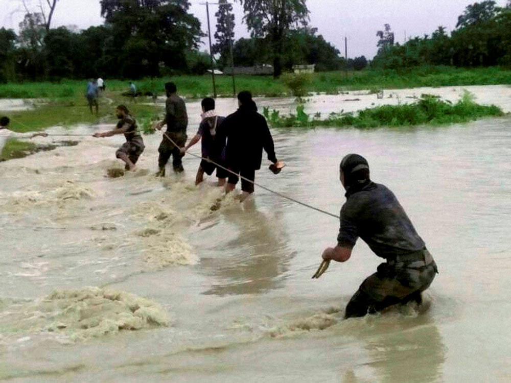 Indian Army soldiers rescue flood affected villagers near India-Bhutan border of Chirang district in Assam on Friday. PTI Photo