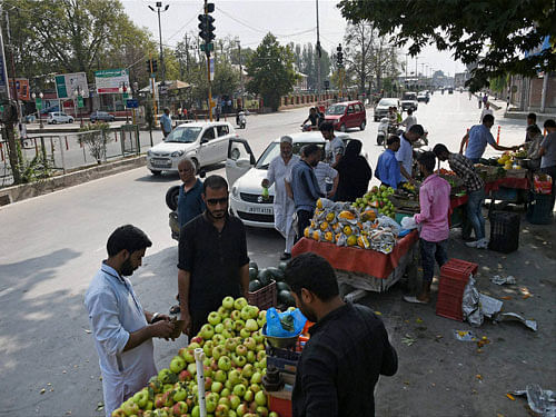 Vendors sell fruit at M A Road after curfew was lifted after 17-day in Srinagar on Tuesday. PTI Photo