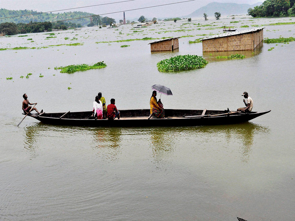 Villagers move to safe place in a boat from the flooded Panikhiti area in Kamrup district of Assam on Thursday. PTI Photo