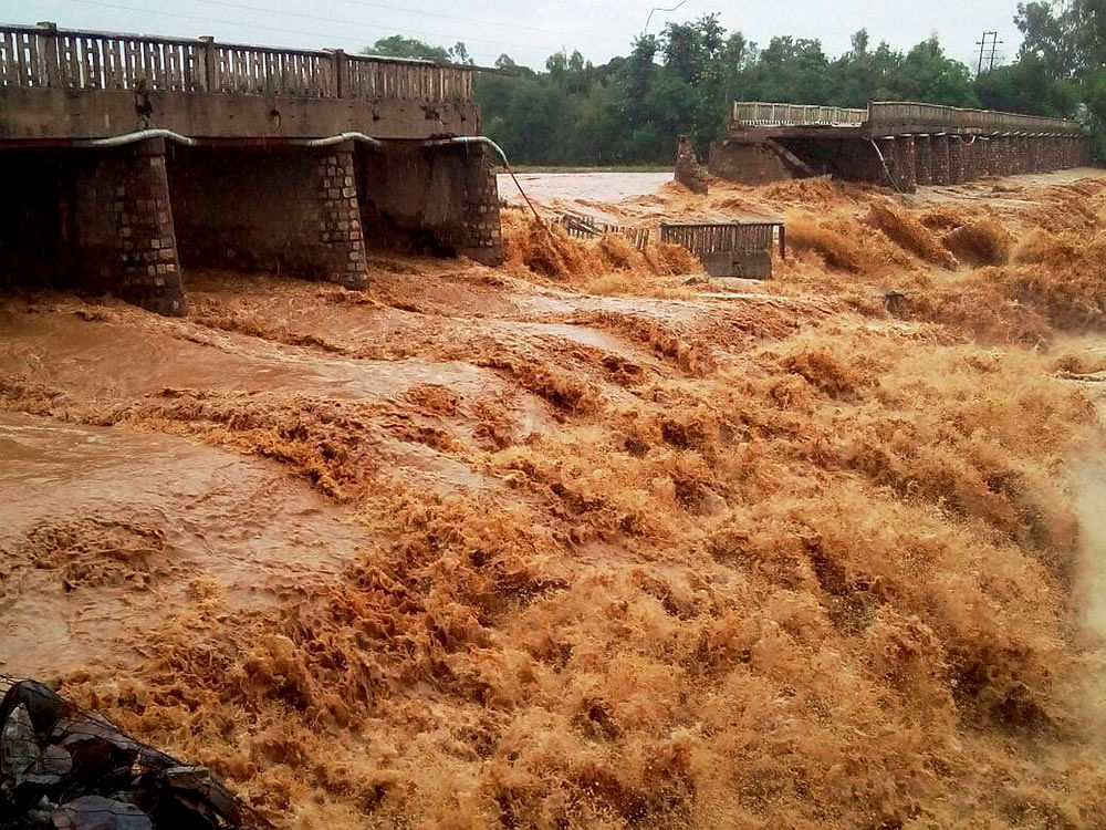  The portion of the Chaunch Khad- Indora-Kandrori bridge that was washed away by the floods, at Indora in Nurpur, Himachal Pradesh on Friday. PTI Photo