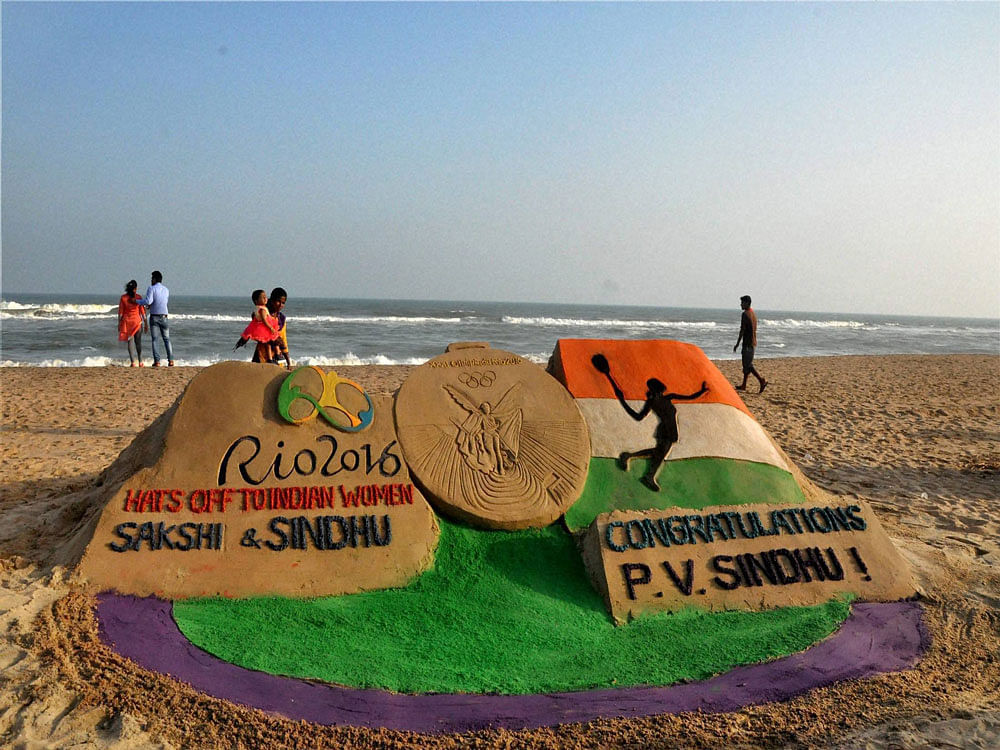 Sand artist Manas Sahoo creates a sand sculpture with message 'Hats off to Indian Women Sakshi and Sindhu' and 'Congratulations PV Sindhu', in Puri on Friday. PTI Photo