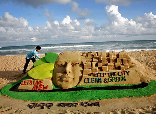Sand artist Manas Sahoo creates a sand sculpture on the eve of local self governance day in Puri on Tuesday. PTI Photo