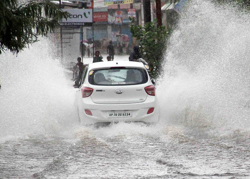 A car moves through a waterlogged road after rains in Allahabad on Thursday. PTI Photo
