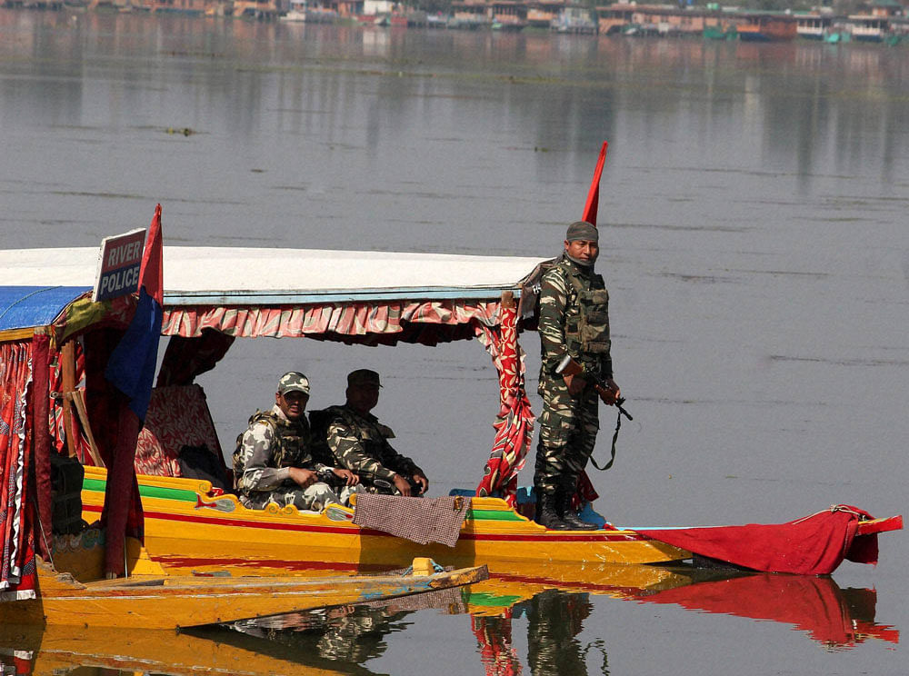 Security personnel, on a Shikara, keep vigil at Dal Lake during the 98th day of curfew in Srinagar on Friday. PTI Photo