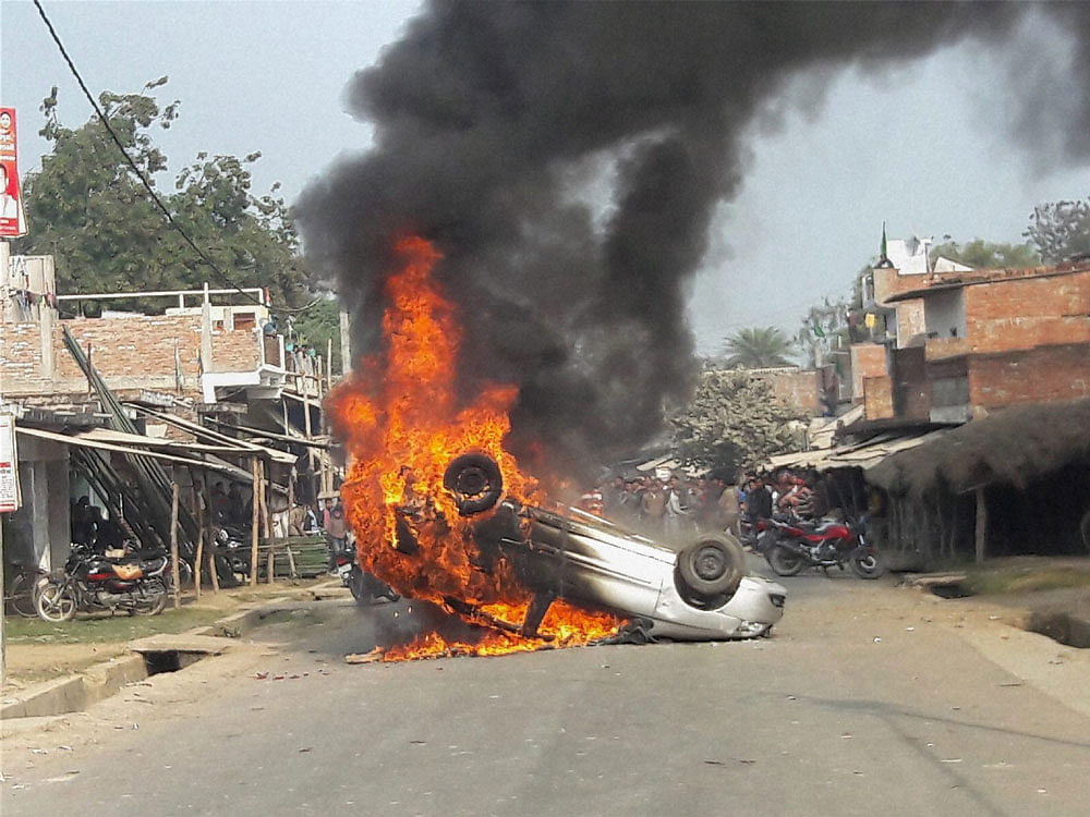 Angy people set ablaze a car at Shukul Bazaar after eleven persons,  including 10 members of a family, were found dead at Mahona village in  Amethi on Wednesday. PTI Photo