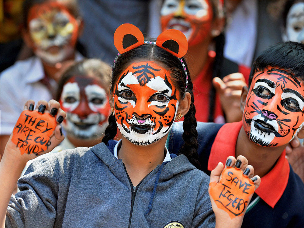  Students paint their faces as tiger during a tiger programme for Inter-school Tiger Fest at Bal Bhavan in Bengaluru on Wednesday. PTI Photo