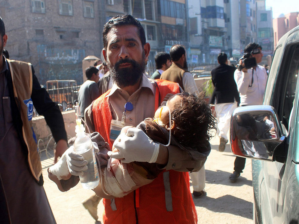  A Pakistani volunteer carries an injured child to a hospital in Peshawar, Pakistan. AP/PTI