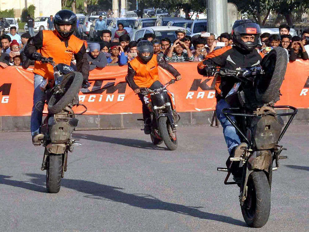 Bikers perform stunts at an event in Faridabad on Sunday. PTI