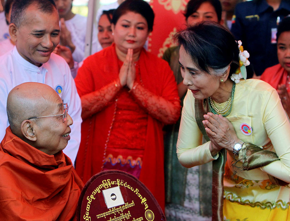 Myanmar State Counsellor and Foreign Minister Aung San Suu kyi, right, pays respect to a monk during a ceremony at Upatasanti Pagoda on the full moon day of Tabaung, the last month of Myanmar calendar, Sunday, March 12, 2017, in Naypyitaw, Myanmar. A...
