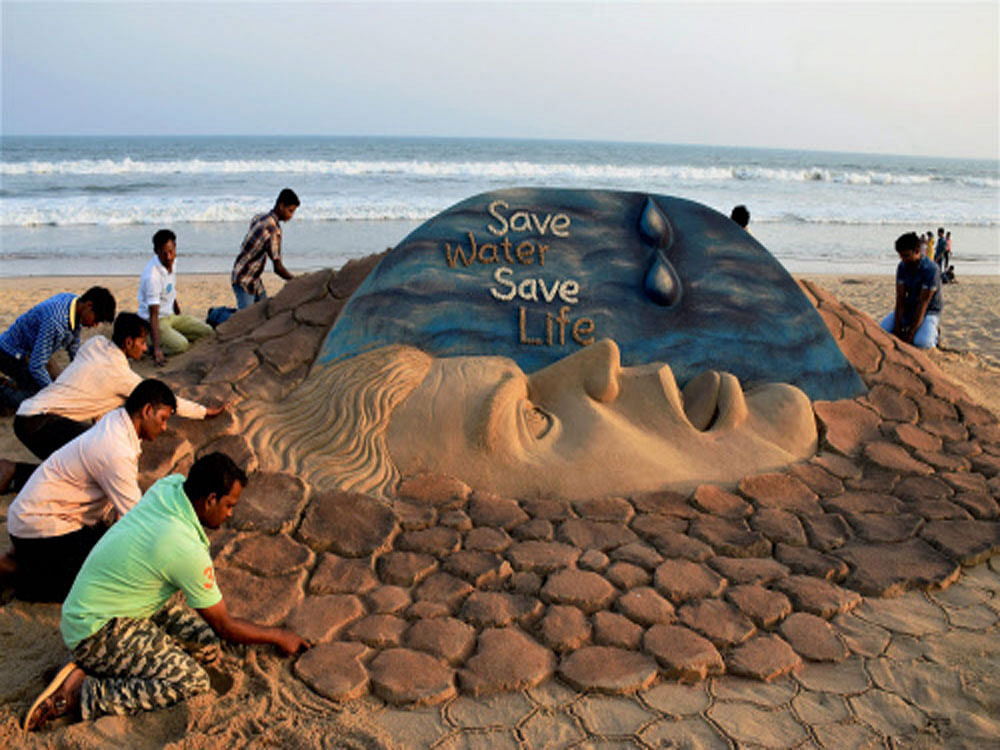 Students of Sand Art School creates a sand sculpture on World Water Day at Puri beach of Odisha on Tuesday. PTI Photo