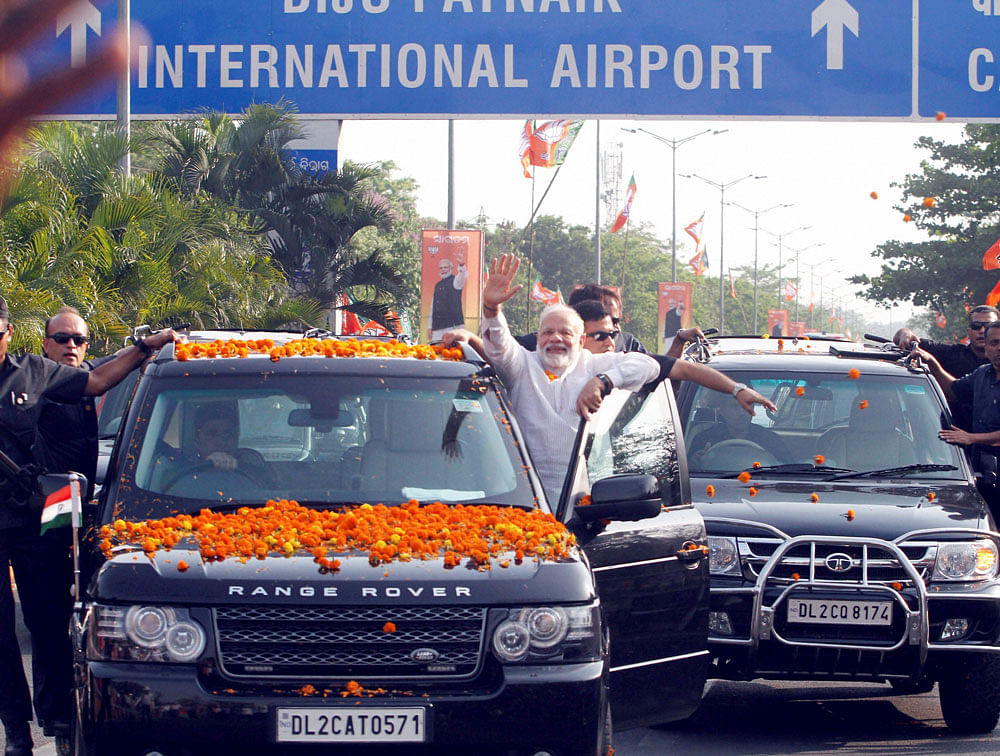 Prime Minister Narendra Modi acknowledges his supporters during a roadshow in Bhubaneswar on Saturday. PTI Photo