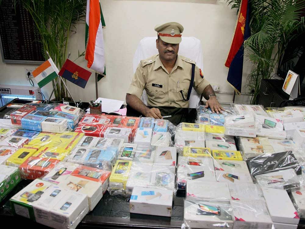 Police showing 130 mobile phones recovered from a gang of six criminals during a press conference in Meerut on Tuesday. PTI Photo