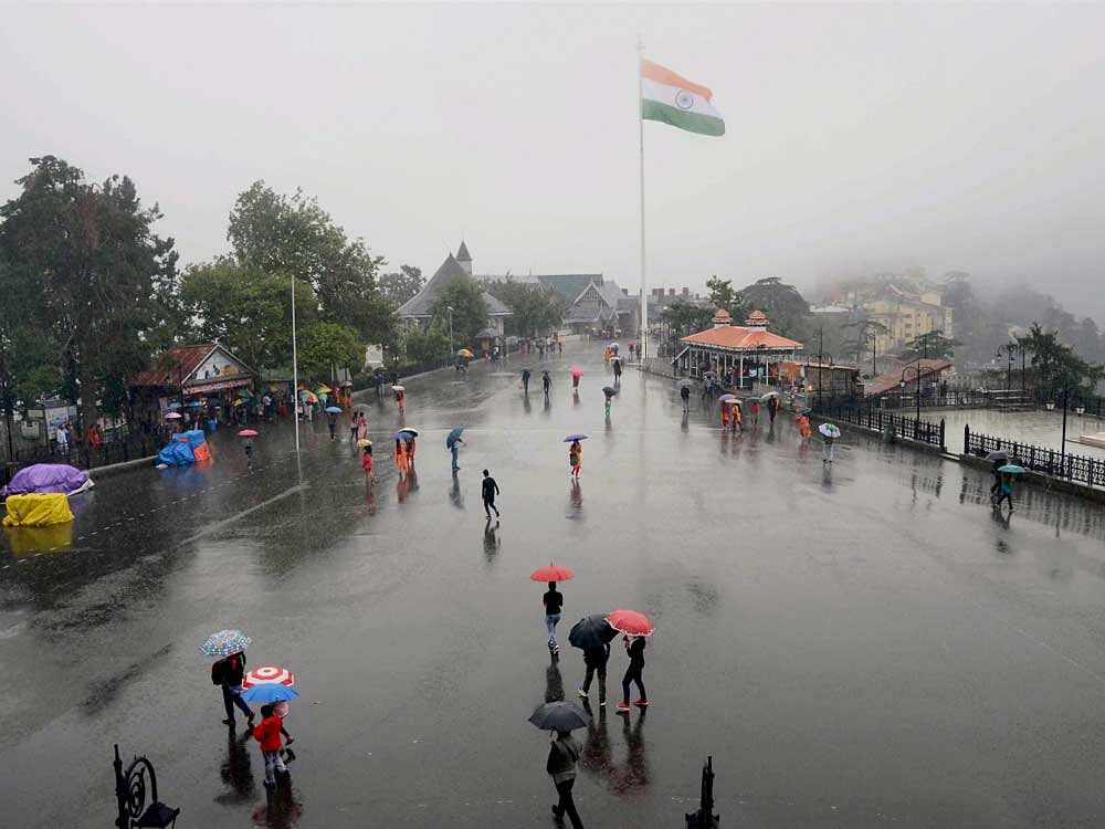  People enjoying the rains at the historic Ridge in Shimla on Wednesday.