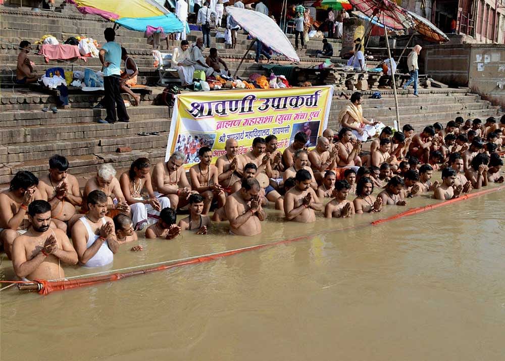 Devotees celebrate 'Shravani Upakarma' on bank of river Ganga in Varanasi on Friday. PTI