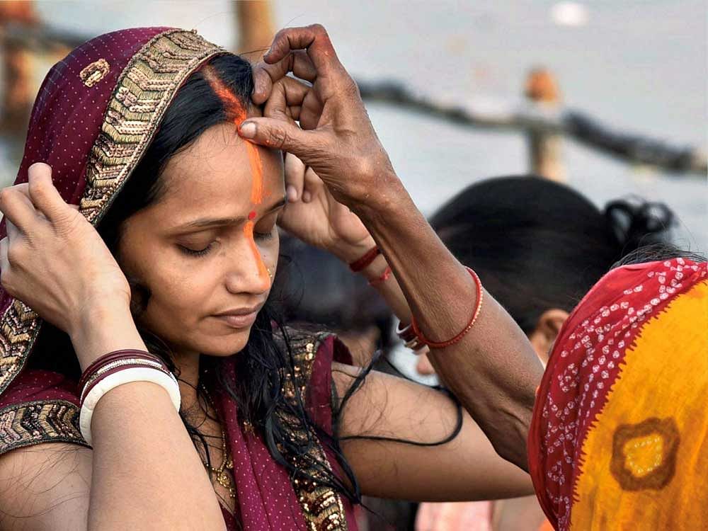Woman devotees put vermillion during rituals ahead of Chhath Puja in Patna on Tuesday.