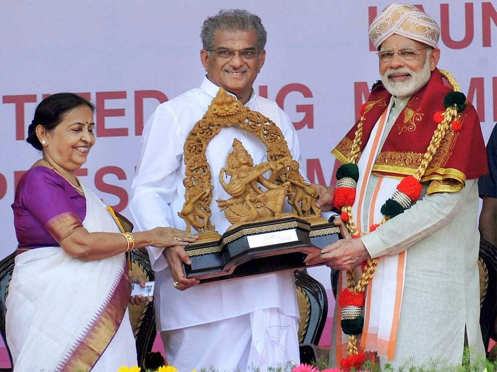 Prime Minister Narendra Modi being presented a memento at the distributiong of the RuPay cards to beneficiaries at the Shri Kshetra Dharmasthala Rural Development Project, at Ujire in Karnataka on Sunday. PTI Photo
