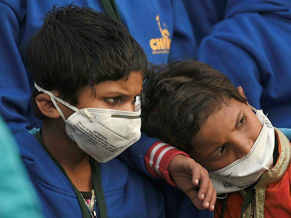 Children wearing air pollution masks attend a demonstration to spread awareness on the problem of air pollution, on Children's Day in New Delhi on Tuesday