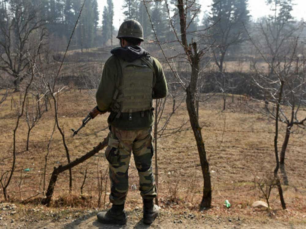  An army soldier stands guard during an encounter with the militants at Futlipora Pakharpora in Budgam district of central Kashmir on Thursday. Four militants were killed in the encounter. PTI Photo